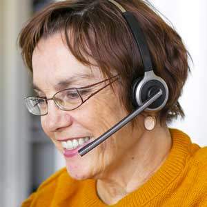 Secrétaire en poste devant son logiciel de gestion des appels entrants avec agenda