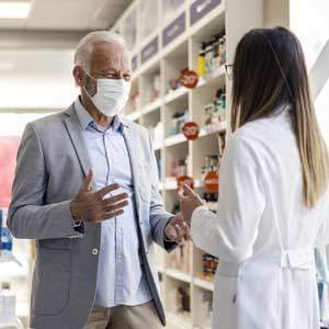 Patient consultant un pharmacien pour des conseils sur un médicament dans une pharmacie