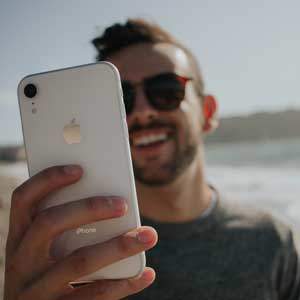 Vacancier détendu à la plage avec son portable